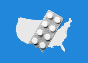 A blister pack of round white pills—possibly an abortion drug—is placed over a white silhouette of the United States on a blue background, highlighting the abortion crisis in Pro-Life states.