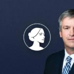 A man in a suit and striped tie stands in front of a dark blue background with a white profile illustration of a woman's face in a circle to his left, representing Barry Moore and the Pro-Life message in the AL-Sen Race.
