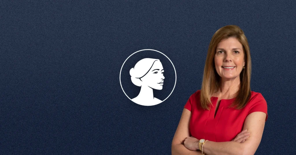 A woman with long light brown hair, wearing a red dress, stands with arms crossed and smiles. Behind her is a navy blue background with a white profile illustration of a woman's face in a circle, representing pro-life group SC-Gov Pamela Evette.