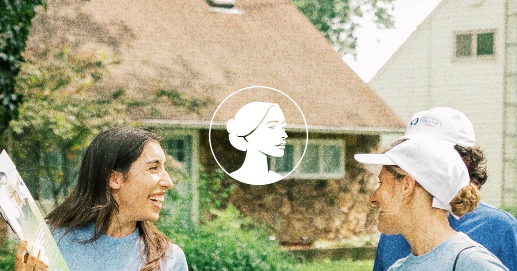 Three people in blue shirts and hats smile and talk outside in front of a house, engaged in Pro-Life Canvassing. A white circular graphic with a woman’s profile is centered over the image.