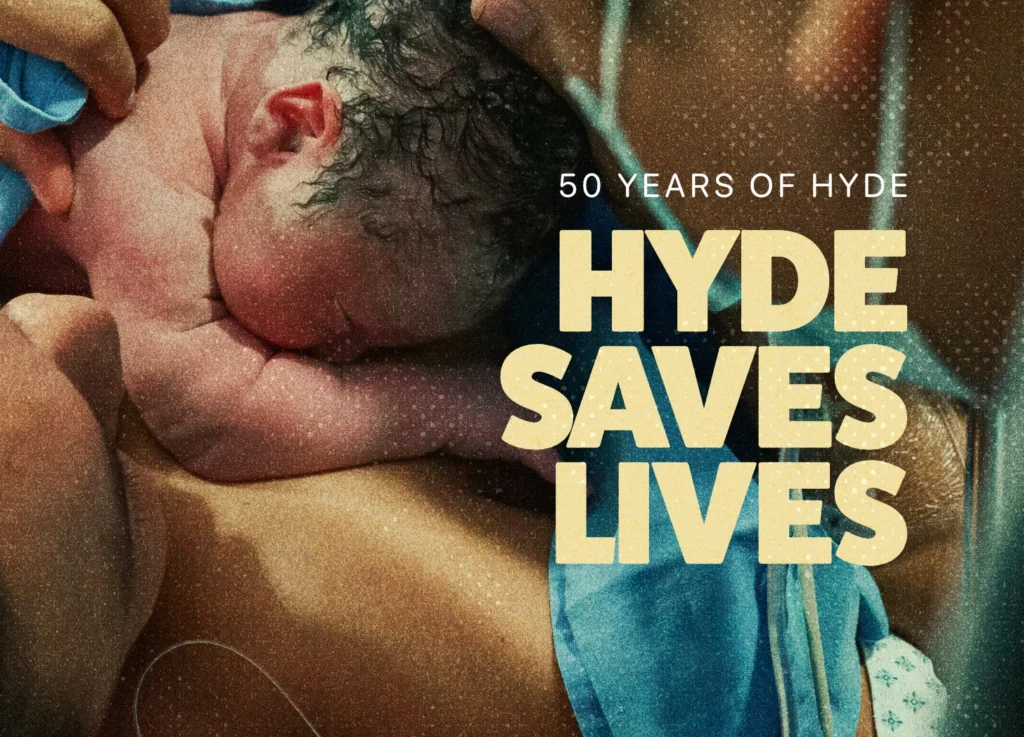 A newborn baby rests on a person’s chest, both partly covered by blue cloth. Large text reads HYDE SAVES LIVES, with smaller text above saying 50 YEARS OF THE PRO-LIFE HYDE AMENDMENT.