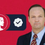 A man in a suit stands in front of a red background with a South Carolina outline, a profile of a woman, and a checkmark in a dark blue box, symbolizing Pro-Life values and SC Governor candidate Alan Wilson’s campaign.