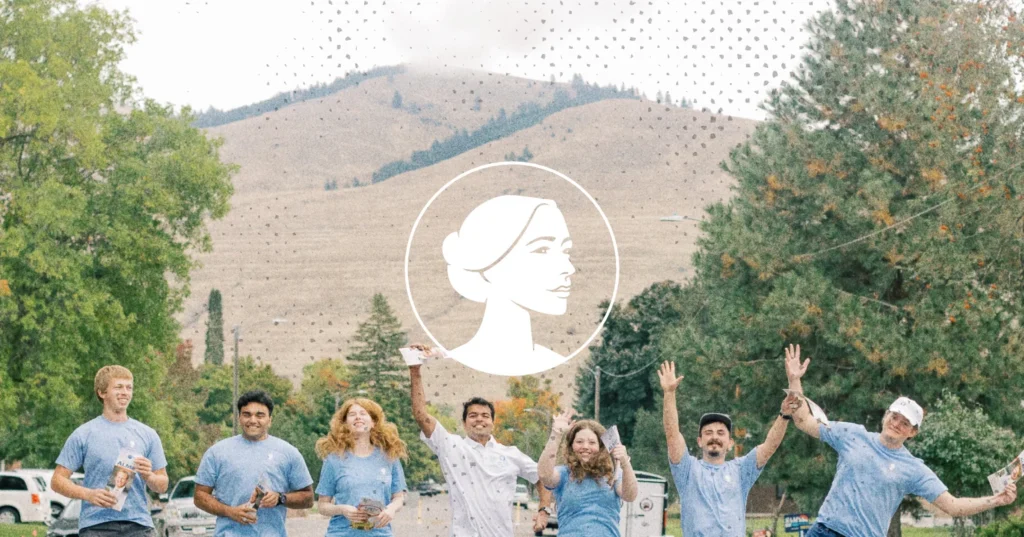 Seven people in matching blue shirts wave at the camera outdoors, with a circular line-art profile of a woman overlaid in the center to highlight Iowa politics.